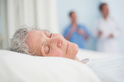 an elderly patient lies in bed with presssure ulcers