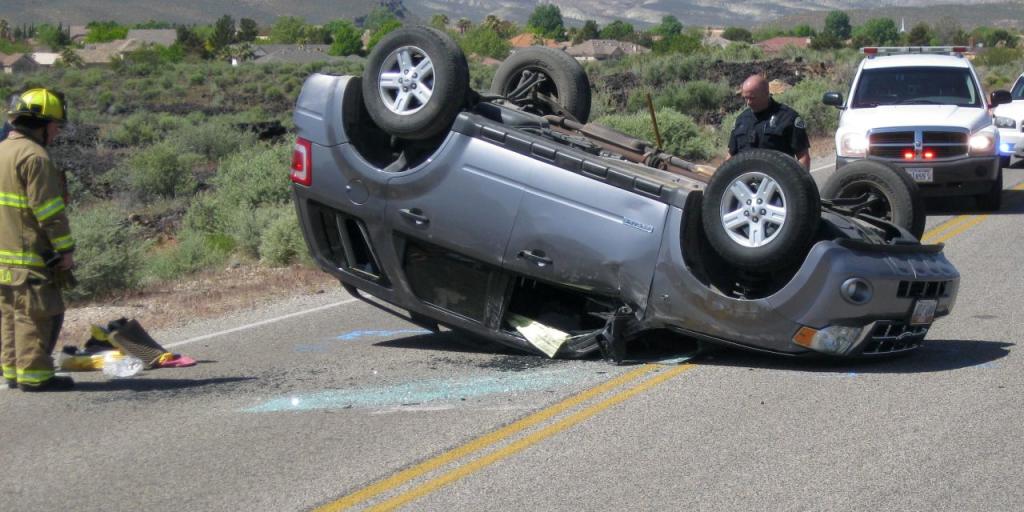 an SUV lies on a hillside after a serious rollover accident