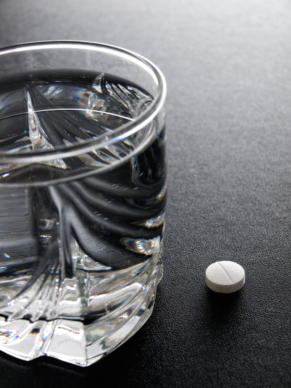 a defective drug sits by a glass of water